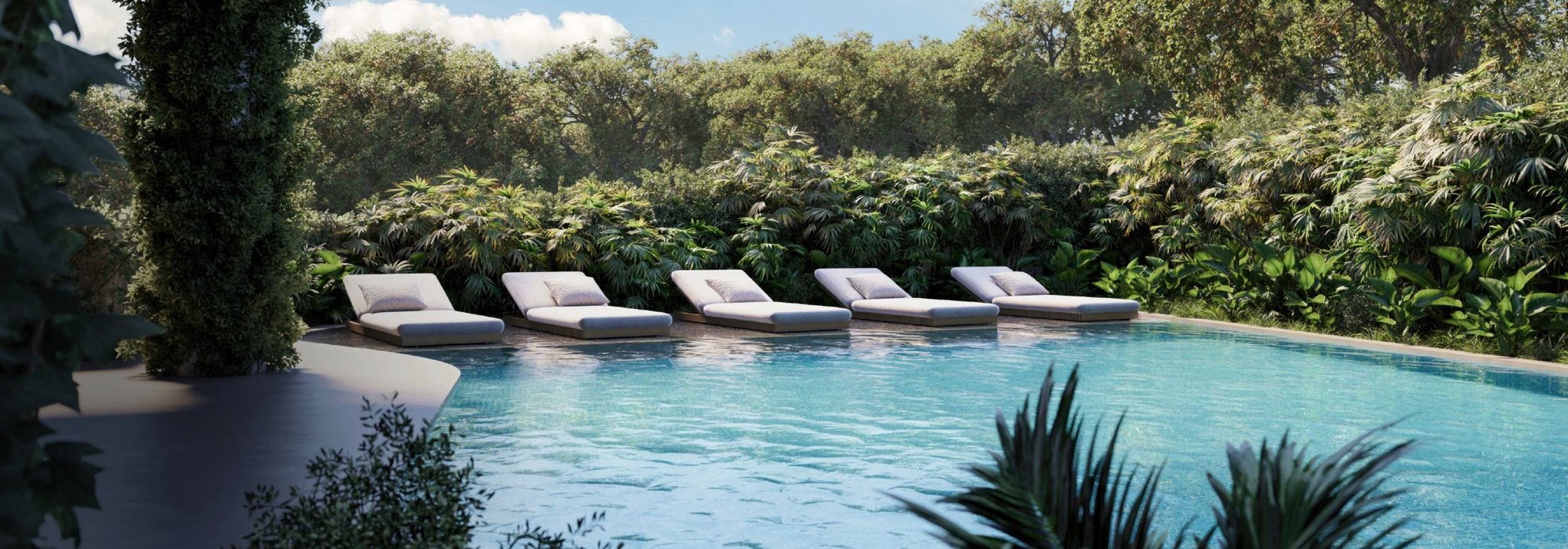 Thermal pool with loungers set in the water, ringed by jungle