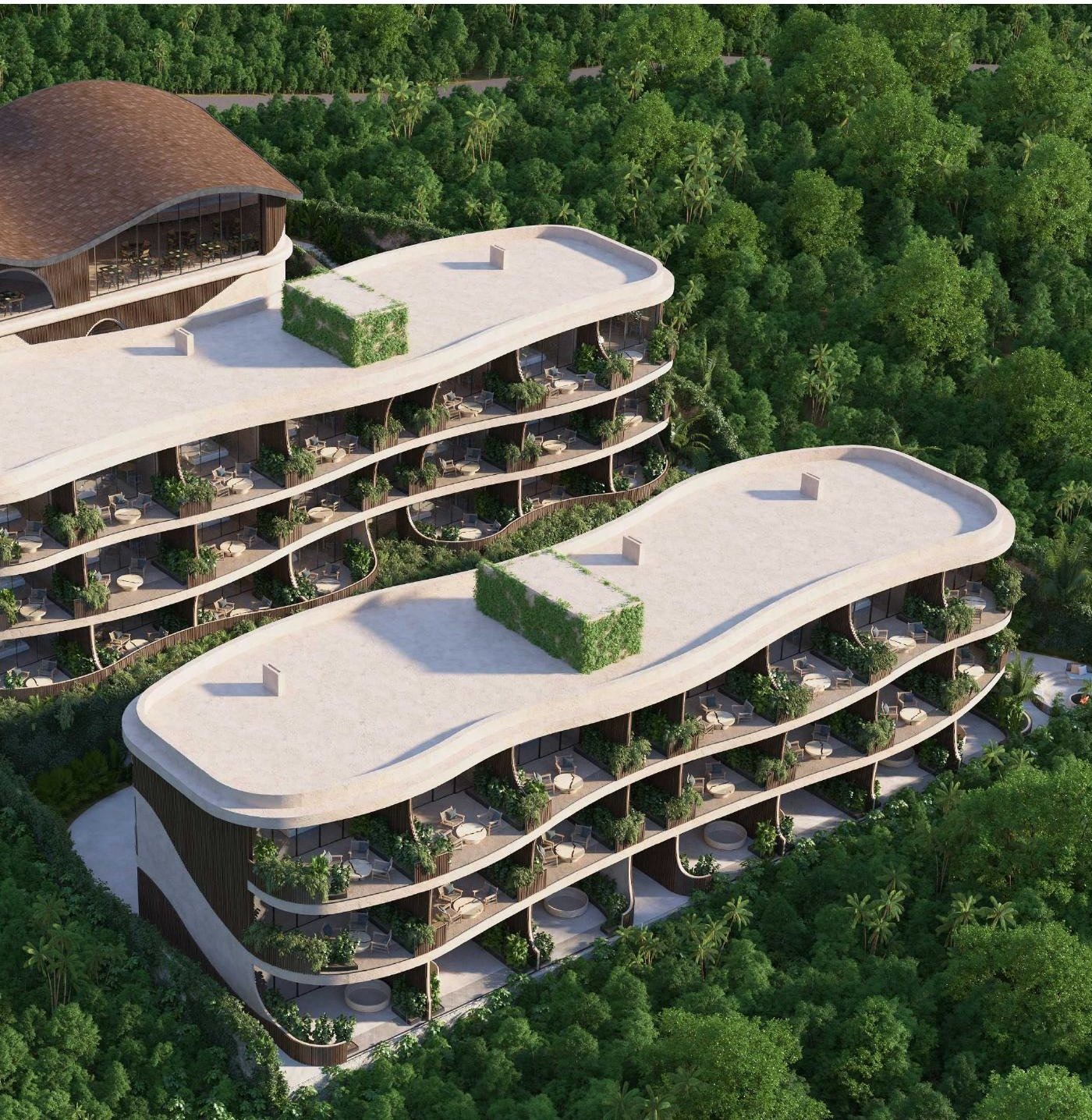 Aerial view of the resort — two curved residence buildings and the wellness center set in jungle